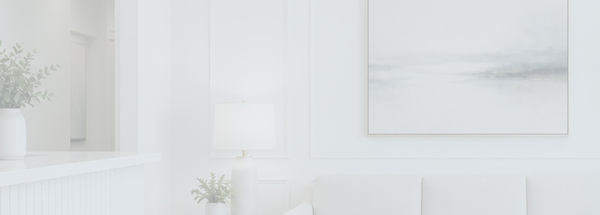 A modern dental office waiting area featuring a white couch, lamp, and decorative plants against light-colored walls.