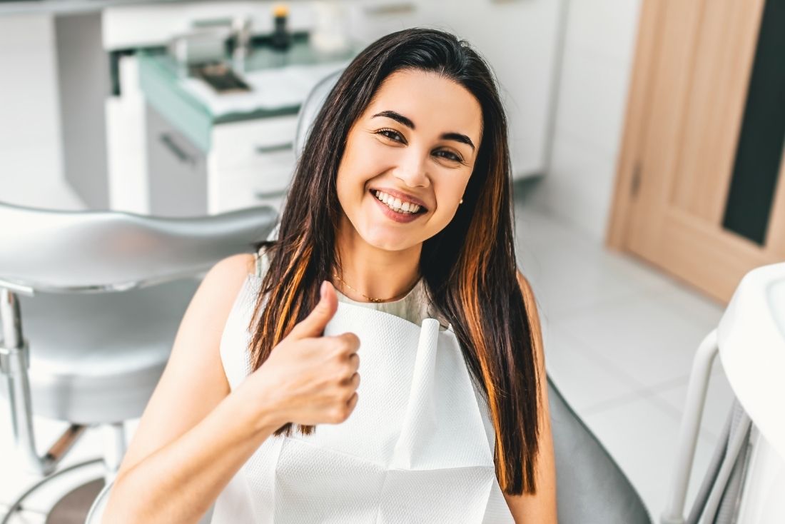A smiling patient giving a thumbs up while seated in a dental chair at a Cape Coral dentist office.